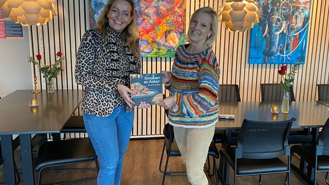 Anne Margrethe og Frid foran kunsten med nye boken om Smaken av Asker